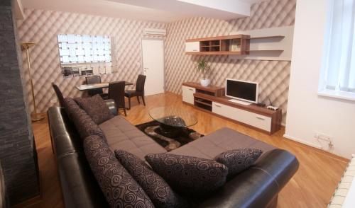 a living room with a couch and a table with a television at Apartments Belgrade in Belgrade