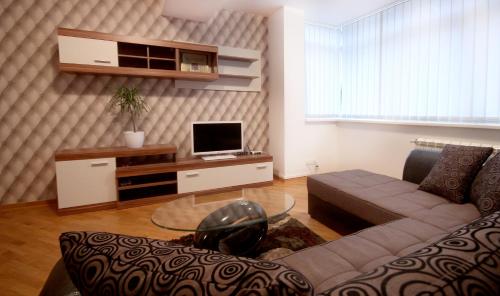 a living room with a couch and a table with a tv at Apartments Belgrade in Belgrade