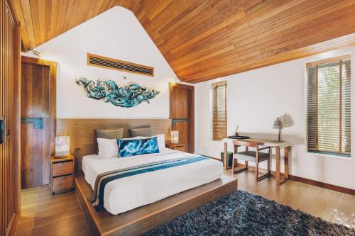 a bedroom with a large bed and a table at Allure Resort in Choeng Mon Beach