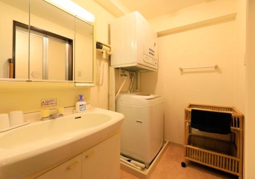 a bathroom with a sink and a refrigerator at Katsuura Hilltop Hotel & Residence in Katsuura