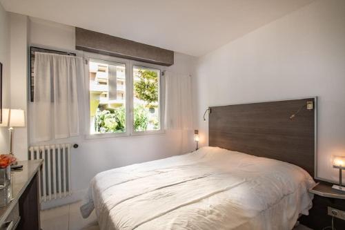 une chambre avec un grand lit et une fenêtre dans l'établissement Croisette: 2BDR Apartment, à Cannes