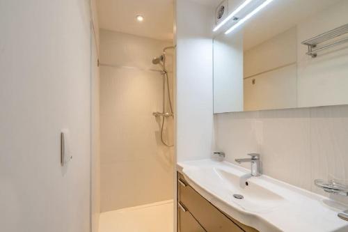 une salle de bain blanche avec un lavabo et une douche dans l'établissement Croisette: 2BDR Apartment, à Cannes