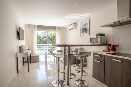 - une cuisine avec un comptoir et des tabourets dans l'établissement Croisette: 2BDR Apartment, à Cannes