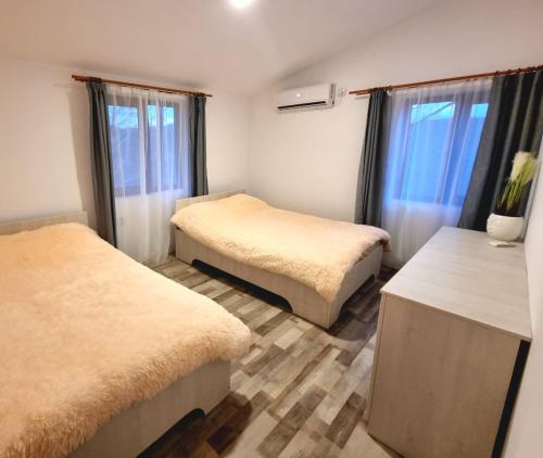 a room with two beds and two windows at Cabana Porolissum in Moigrad