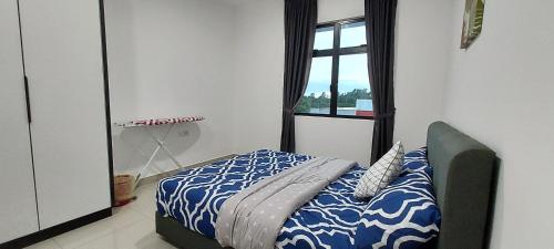 a bedroom with a bed with a blue and white comforter at Ai Qaseh Desaru Penawar Pool Apartment Homestay in Bandar Penawar