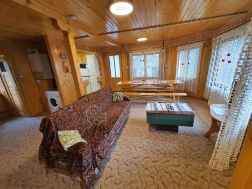 sala de estar con sofá y mesa en VillaRonda numai în intregime, max 6 persoane, min 4 zile, 130 mp bine incalziti, 3 dormitoare, sufragerie, bucatarie, veranda, terasa, curte cu parcare si grătar, ideala pentru lucru la distanta, insorita, discreta, zona linistita, usor accesibila en Predeal