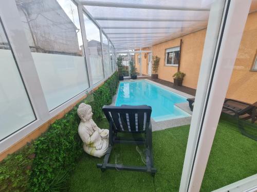 a patio with a chair and a swimming pool at Casa Particular das Pedras in Vila Nova de Gaia