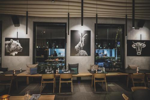 a restaurant with tables and chairs and pictures of animals at Aves Arosa in Arosa