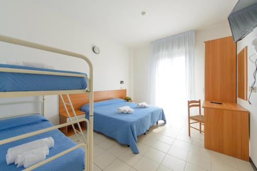 a bedroom with two bunk beds and a table at Hotel Paloma in Rimini