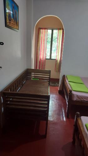 a room with two beds and a window at Green House in Adams Peak