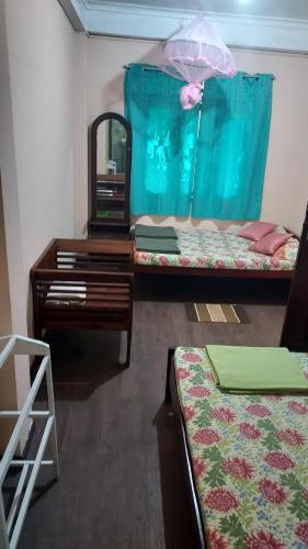 a room with two beds and a table and a mirror at Green House in Adams Peak