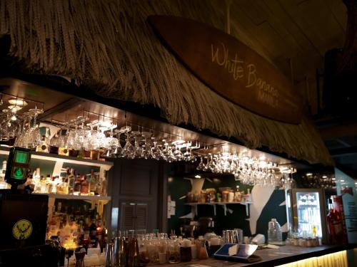 a bar with wine glasses hanging from a ceiling at WHITE BANANA Manila - NEW in Manila