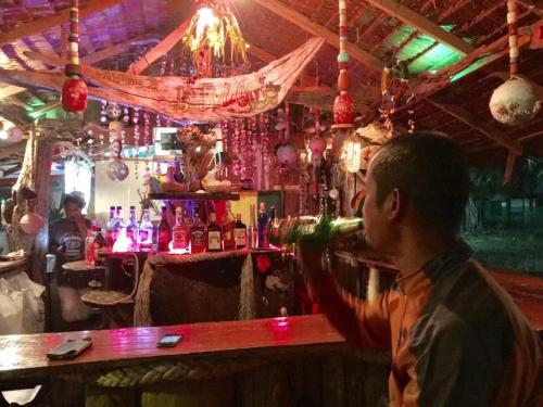 een man die een glas wijn drinkt in een bar bij Koh Ngai Sea Open Resort in Ko Ngai