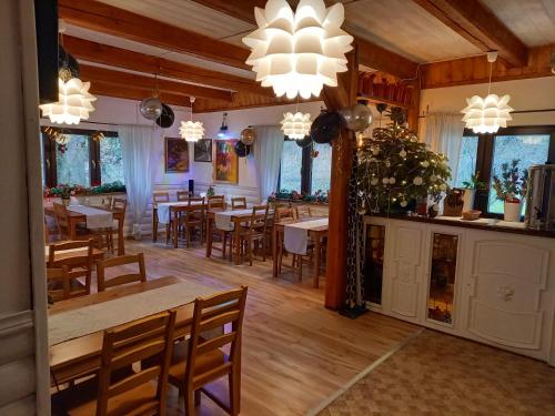 a dining room with tables and chairs and chandeliers at ZACISZE in Karłów