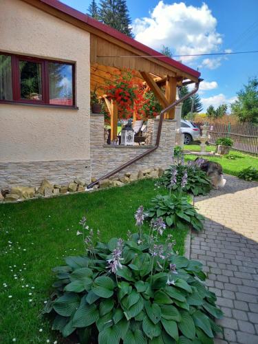 ein Haus mit einem Garten mit Blumen im Hof in der Unterkunft ZACISZE in Karłów