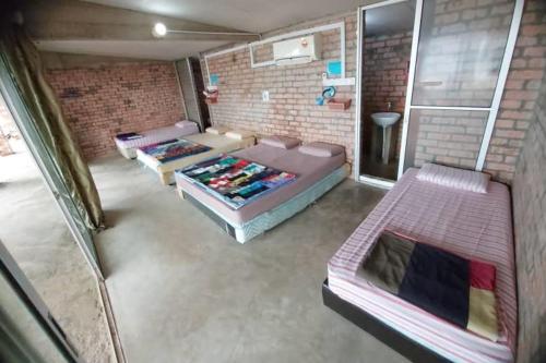 um quarto com duas camas e uma parede de tijolos em OYO HOME 90641 Naga Puri Beach Retreat em Kuala Penyu