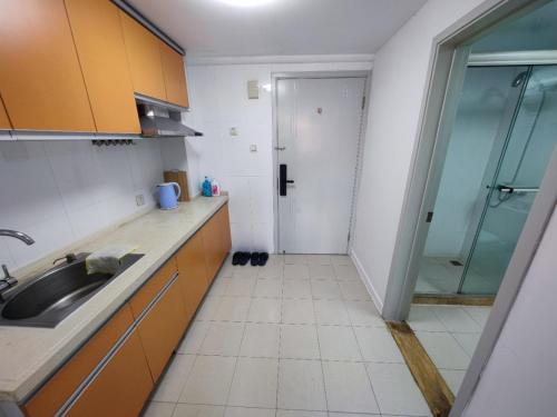 a kitchen with a sink and a glass shower at iNestin Shanghai Apt Xinjinqiao Road in Shanghai