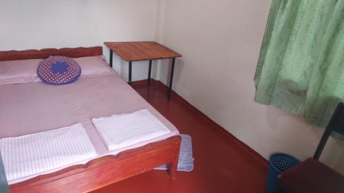 a small room with a bed and two tables at Green House in Adams Peak