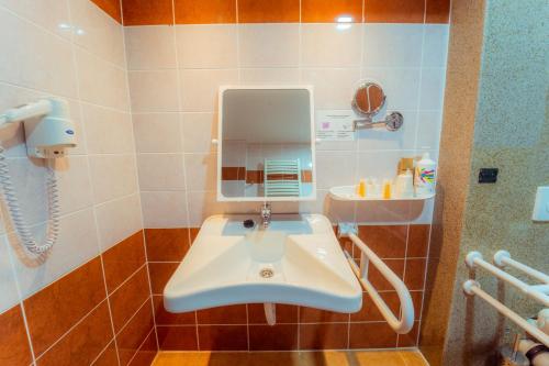 a bathroom with a sink and a phone at Hotel Perla in Slănic-Moldova