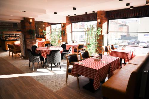 - un restaurant avec des tables et des chaises dans une salle dans l'établissement Anemon Uşak Hotel, à Uşak