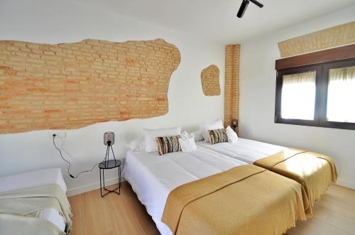 a bedroom with a large bed and a brick wall at Casa Limon, Patio y Parking. in Granada