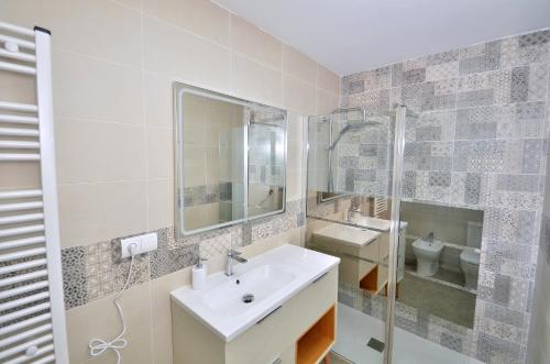 a white bathroom with a sink and a shower at Casa Limon, Patio y Parking. in Granada