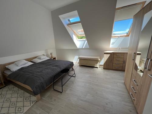 a bedroom with a bed and a skylight at JÁNHÁZ Apartman Révfülöp in Révfülöp