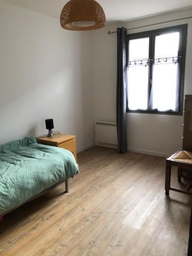 ein Schlafzimmer mit Bett, Schreibtisch und zwei Fenstern in der Unterkunft Maison Proche Chartres 5 LITS PARKING in Chartres