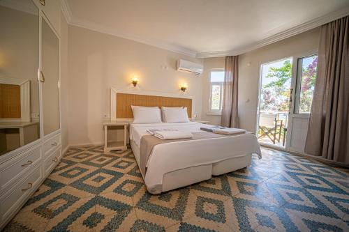 a bedroom with a bed and a large window at Chillos Beach in Marmaris