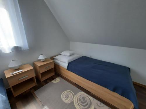 1 dormitorio pequeño con 1 cama y 2 mesitas de noche en Panka Üdülőház-Bónom zug, en Gyomaendrőd