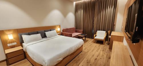 Habitación de hotel con cama y silla en Hotel Gorbandh en Udaipur