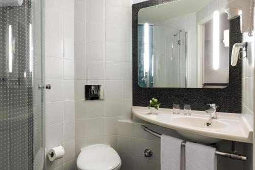 a bathroom with a sink and a toilet and a mirror at ibis Ankara Airport Hotel in Ankara