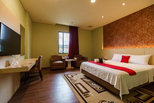 a hotel room with a large bed and a desk at RedDoorz Plus near Dunia Fantasi Ancol in Jakarta