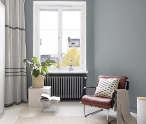 ein Wohnzimmer mit einem Stuhl und einem Fenster in der Unterkunft Beautiful studio apartment in the heart of trendy Kallio in Helsinki