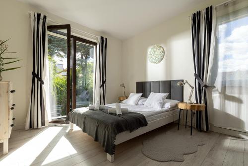 a bedroom with a bed and a large window at Małe Letnisko, butikowy pensjonat blisko Zatoki in Puck