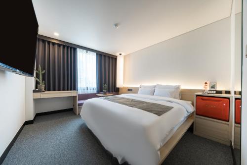 a hotel room with a large bed and a television at Jamsil Stay Hotel in Seoul