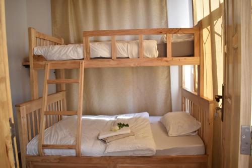 a bunk bedded room with two bunk beds with white pillows at Tiny house with amazing view in Arusha