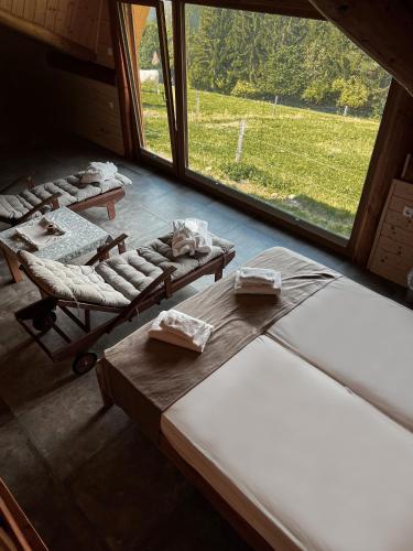 a room with four beds and a large window at Guesthouse Smogavc in Zreče
