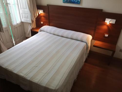 Habitación de hotel con cama con sábanas blancas en B&B Casa Laganà, en Reggio Calabria