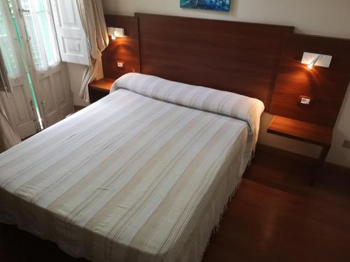 a hotel room with a bed with white sheets at B&B Casa Laganà in Reggio di Calabria