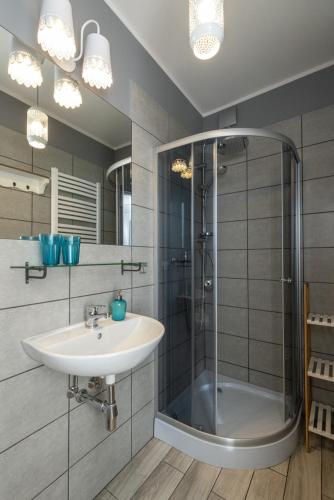 a bathroom with a sink and a shower at Małe Letnisko, butikowy pensjonat blisko Zatoki in Puck