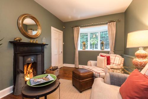 a living room with a fireplace and a mirror at Hideaway country cottage near Edinburgh in Penicuik