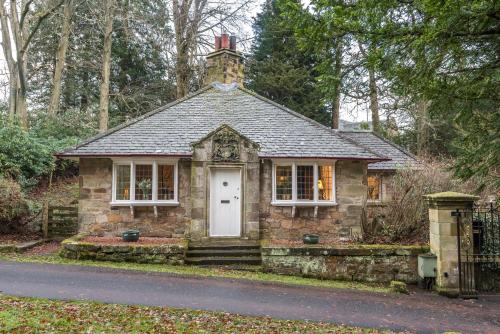 a small stone house in the middle of a street at Hideaway country cottage near Edinburgh in Penicuik