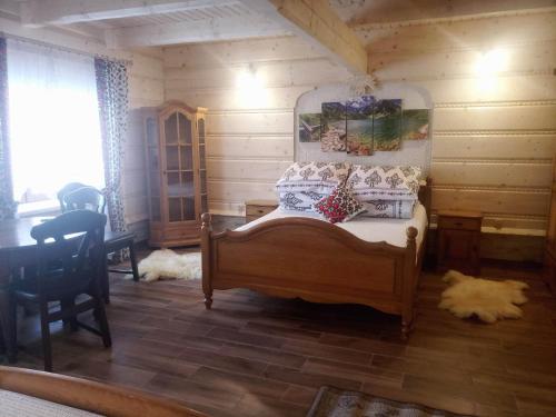 1 dormitorio con 1 cama en una cabaña de madera en U Huraja en Groń