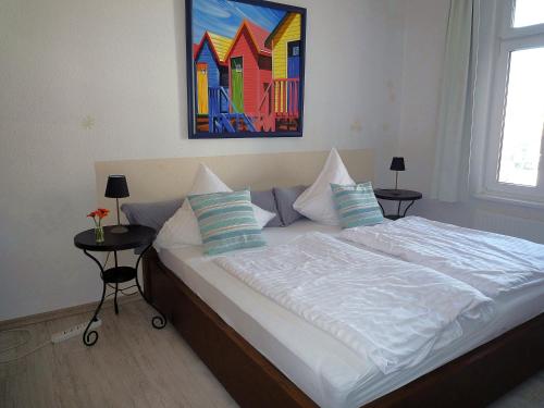 a bedroom with a bed with a painting on the wall at Villa-Emmy-App-02 in Ahlbeck