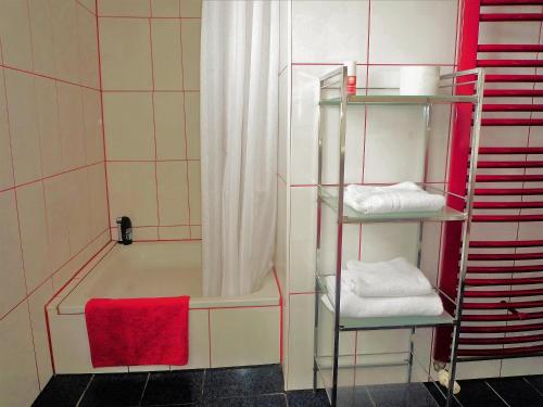 a bathroom with a bath tub with a red towel at Villa-Emmy-App-02 in Ahlbeck