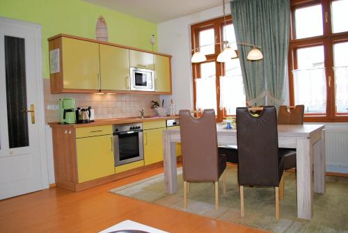 eine Küche mit einem Holztisch und gelben Schränken in der Unterkunft Bellevue App. 14 in Ahlbeck