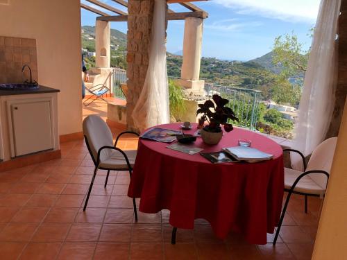 a dining room with a red table and a view at Villa Hermes Case Vacanza in Lipari