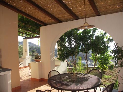 a patio with a table and a potted tree at Villa Hermes Case Vacanza in Lipari