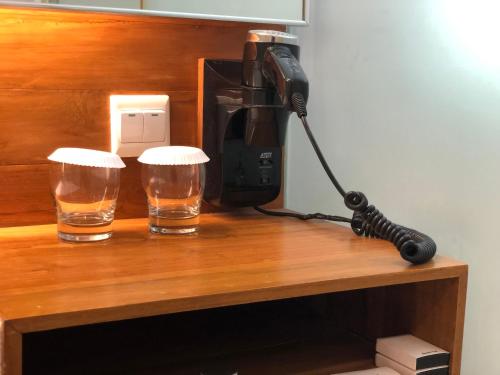 a camera and two glasses on a wooden table at Turi Beach Resort in Nongsa
